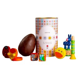 Oeuf de Pâques au chocolat au lait avec une surprise pour les enfants dans une boîte cylindrique